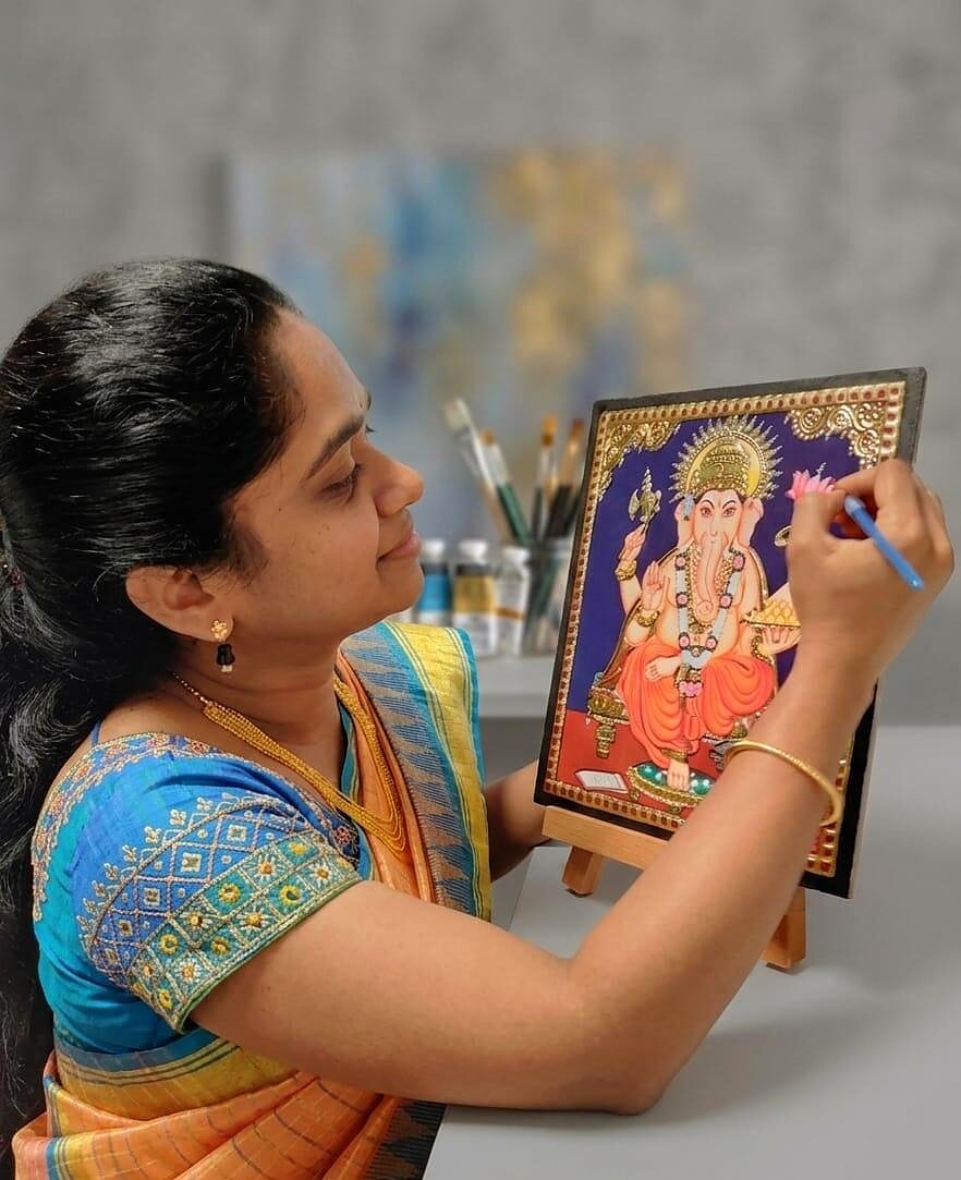 Ratnadevi Gogula painting a traditional Tanjore-style work